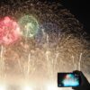 花火大会をスマホで撮影する人