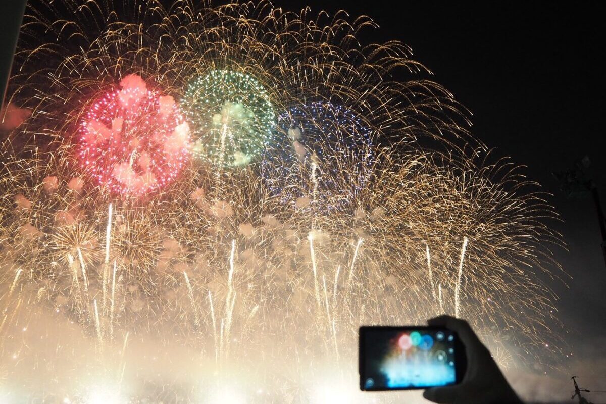 花火大会をスマホで撮影する人